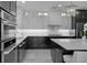 Modern kitchen featuring sleek black and white cabinets, stainless steel appliances, and elegant countertop lighting at 5018 S The Riviera St, Tampa, FL 33609
