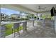 A covered outdoor kitchen with granite countertops, built-in grill, bar seating and a ceiling fan at 5018 S The Riviera St, Tampa, FL 33609