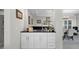 Stylish wet bar with white cabinetry, dark countertop, mirror backsplash, and decorative lighting at 5018 S The Riviera St, Tampa, FL 33609
