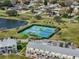 Aerial view of the community tennis courts, surrounded by lush greenery, palms and residential buildings at 5094 Starfish Se Dr # E, St Petersburg, FL 33705