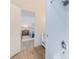 Clean bathroom with a tub/shower combination, white tiles, and a view into the bedroom at 5094 Starfish Se Dr # E, St Petersburg, FL 33705