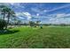 Expansive community green space featuring manicured lawn, picnic benches, and a serene lake view at 5094 Starfish Se Dr # E, St Petersburg, FL 33705