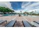 Relaxing community pool with comfortable lounge chairs, a brick-paved deck, and lush palm trees surrounding at 5094 Starfish Se Dr # E, St Petersburg, FL 33705