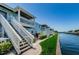 Charming waterfront condos with stairs leading to private balconies, set against a clear blue sky at 5094 Starfish Se Dr # E, St Petersburg, FL 33705