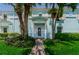Charming light blue home featuring a white door, lush landscaping, and a welcoming brick walkway at 5094 Starfish Se Dr # E, St Petersburg, FL 33705