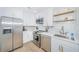Modern white kitchen with stainless steel appliances, ample cabinet space, and sleek countertops at 5094 Starfish Se Dr # E, St Petersburg, FL 33705