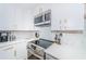 Modern kitchen with white cabinets, stainless steel appliances, and elegant countertops and backsplash at 5094 Starfish Se Dr # E, St Petersburg, FL 33705