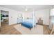 Spacious bedroom with a four-poster bed, white plank walls, and warm wood flooring at 5094 Starfish Se Dr # E, St Petersburg, FL 33705