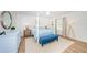 Bright bedroom with a four-poster bed, light wood flooring, and blue accents at 5094 Starfish Se Dr # E, St Petersburg, FL 33705