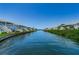Picturesque waterfront view showcasing blue condos and a tranquil canal under a clear sky at 5094 Starfish Se Dr # E, St Petersburg, FL 33705