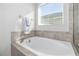Bright bathroom featuring a soaking tub beneath a window with blinds at 5108 Suncatcher Dr, Wesley Chapel, FL 33545