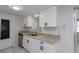 Modern kitchen with white cabinets, granite countertops, stainless steel appliances, and sleek hardware at 5203 Overton Dr, New Port Richey, FL 34652
