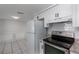 Kitchen featuring stainless steel appliances, granite countertops, white cabinetry and tile backsplash at 5203 Overton Dr, New Port Richey, FL 34652