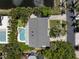 An aerial view showcases the home's swimming pool and meticulously landscaped yard, set against the backdrop of a lake at 6113 Kipps Colony W Dr, Gulfport, FL 33707