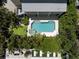 Aerial shot of a home's backyard, featuring a pool, spa, patio, and lounge area surrounded by lush greenery at 6113 Kipps Colony W Dr, Gulfport, FL 33707