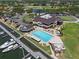 Aerial view showcasing a clubhouse, pool, and marina, surrounded by lush greenery and golf course at 6113 Kipps Colony W Dr, Gulfport, FL 33707