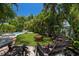 A relaxing backyard is enhanced by comfortable seating arranged around a fire pit near a swimming pool at 6113 Kipps Colony W Dr, Gulfport, FL 33707