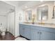 Bathroom featuring dual sinks, marble countertops, and wood floors with custom accents at 6113 Kipps Colony W Dr, Gulfport, FL 33707
