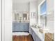Bathroom featuring dual sinks, marble countertops, and wood floors with a large window at 6113 Kipps Colony W Dr, Gulfport, FL 33707