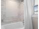 Well-lit bathroom featuring tiled tub/shower and window at 6113 Kipps Colony W Dr, Gulfport, FL 33707
