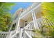 Elegant coastal home featuring a white exterior, multiple balconies, and lush tropical foliage at 6113 Kipps Colony W Dr, Gulfport, FL 33707