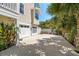 A spacious driveway leads to a two-car garage, surrounded by lush tropical landscaping at 6113 Kipps Colony W Dr, Gulfport, FL 33707