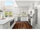 Modern kitchen with white cabinets, stainless steel appliances, and hardwood floors at 6113 Kipps Colony W Dr, Gulfport, FL 33707