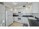 Traditional kitchen with white cabinets, sleek countertops, modern appliances, and tile flooring at 6322 Palma Del Mar S Blvd # 706, St Petersburg, FL 33715