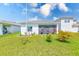Landscaped backyard featuring healthy lawn and a partially screened-in patio at 6333 Milestone Loop, Palmetto, FL 34221