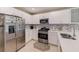 Well-lit kitchen featuring stainless steel appliances, ample white cabinetry, and a stylish tile backsplash for a modern touch at 6333 Milestone Loop, Palmetto, FL 34221