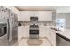 Well-lit kitchen featuring stainless steel appliances, ample white cabinetry, and a stylish tile backsplash for a modern touch at 6333 Milestone Loop, Palmetto, FL 34221