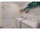 Neat laundry room features a washer, dryer, and overhead shelf for storage at 6333 Milestone Loop, Palmetto, FL 34221
