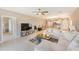 Open-concept living room featuring tile floors and neutral decor, leading into the kitchen and dining areas at 6333 Milestone Loop, Palmetto, FL 34221