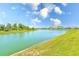 Scenic pond view with lush landscaping and beautiful homes in the distance under a bright blue sky at 6333 Milestone Loop, Palmetto, FL 34221