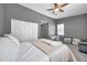 Spacious bedroom with a ceiling fan, adjacent desk, and bright windows, perfect for relaxation at 7070 Opal Dr, Largo, FL 33773