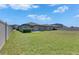 View of the backyard with a green lawn, a concrete patio area, and privacy fencing, ideal for outdoor enjoyment at 7236 Salt River Ave, Sun City Center, FL 33573