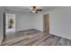Laminate flooring, a ceiling fan, and neutral paint color. Additional bedroom is visible through a doorway at 7236 Salt River Ave, Sun City Center, FL 33573