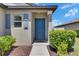 Inviting front entryway with a blue door, neat landscaping, and a 'hello' welcome mat at 7236 Salt River Ave, Sun City Center, FL 33573