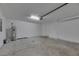 A spacious garage featuring white walls, a garage door, a water heater, and concrete flooring at 7236 Salt River Ave, Sun City Center, FL 33573