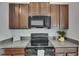 Close-up of dark kitchen appliances, granite countertops, and dark cabinetry in a modern kitchen at 7236 Salt River Ave, Sun City Center, FL 33573
