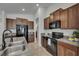 Well-equipped kitchen with dark wood cabinets, granite countertops, and modern stainless steel appliances at 7236 Salt River Ave, Sun City Center, FL 33573