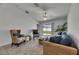 Bright living room with wicker furniture set, tile flooring, ceiling fan, and sliding glass doors to the back yard at 7236 Salt River Ave, Sun City Center, FL 33573