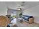 Cozy living room with large windows, neutral paint, tile floors, ceiling fan and comfortable wicker furniture at 7236 Salt River Ave, Sun City Center, FL 33573