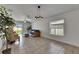 Bright living room with tile flooring, a modern light fixture, and sliding glass doors to the outside at 7236 Salt River Ave, Sun City Center, FL 33573
