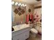 Bathroom features a vanity, decorative mirror, and a floral shower curtain, adding a touch of charm at 7465 Bay Island S Dr # 211, South Pasadena, FL 33707