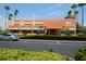 Charming condominium exterior with lush landscaping, palm trees, and convenient parking at 7465 Bay Island S Dr # 211, South Pasadena, FL 33707