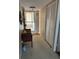 The condo entry hall has a carpet floor, storage closet, and is decorated with wall art and a small bench at 7465 Bay Island S Dr # 211, South Pasadena, FL 33707