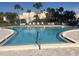 Community pool with lounge seating, palm trees, and a relaxing environment for residents at 7465 Bay Island S Dr # 211, South Pasadena, FL 33707