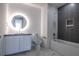 Modern bathroom featuring bathtub, a vanity, a large mirror with lighting, and marble tile flooring at 777 3Rd N Ave # 1501, St Petersburg, FL 33701