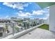 A covered balcony boasts a city skyline view beyond the modern railing and partial grassy area at 777 3Rd N Ave # 707, St Petersburg, FL 33701